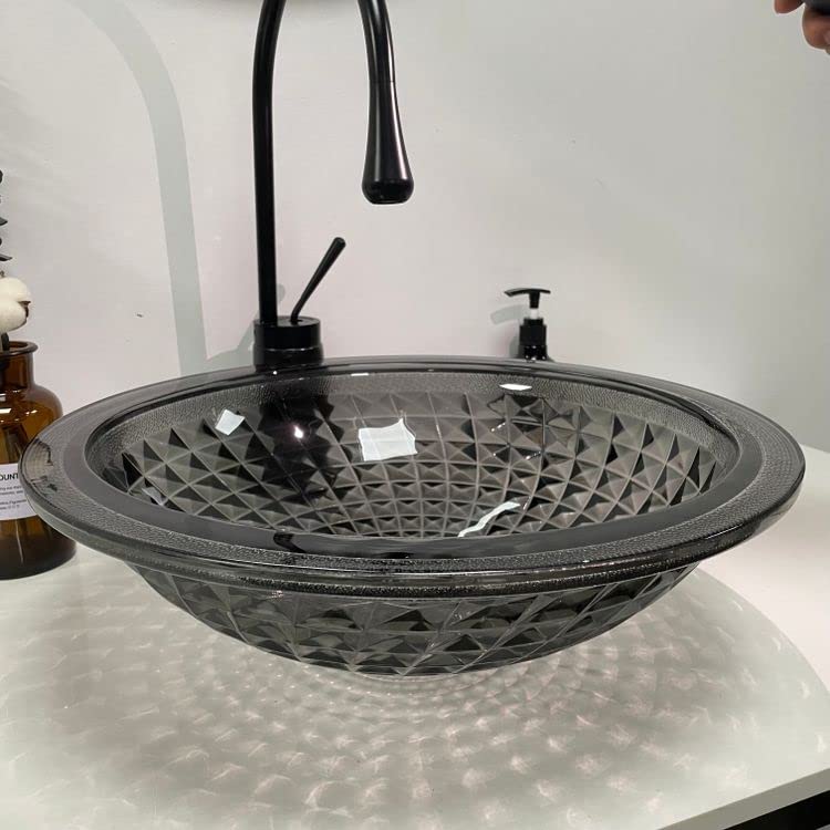 Smoked black glass vessel bowl sink above counter showing center drain opening and no overflow