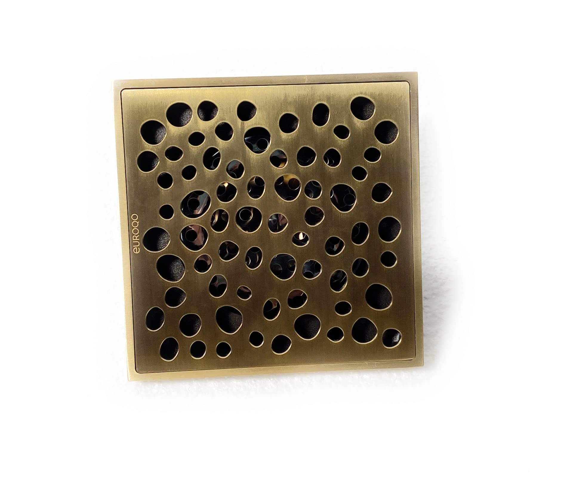 Brass shower drain showing internal mechanical odor trap insert under removable grate