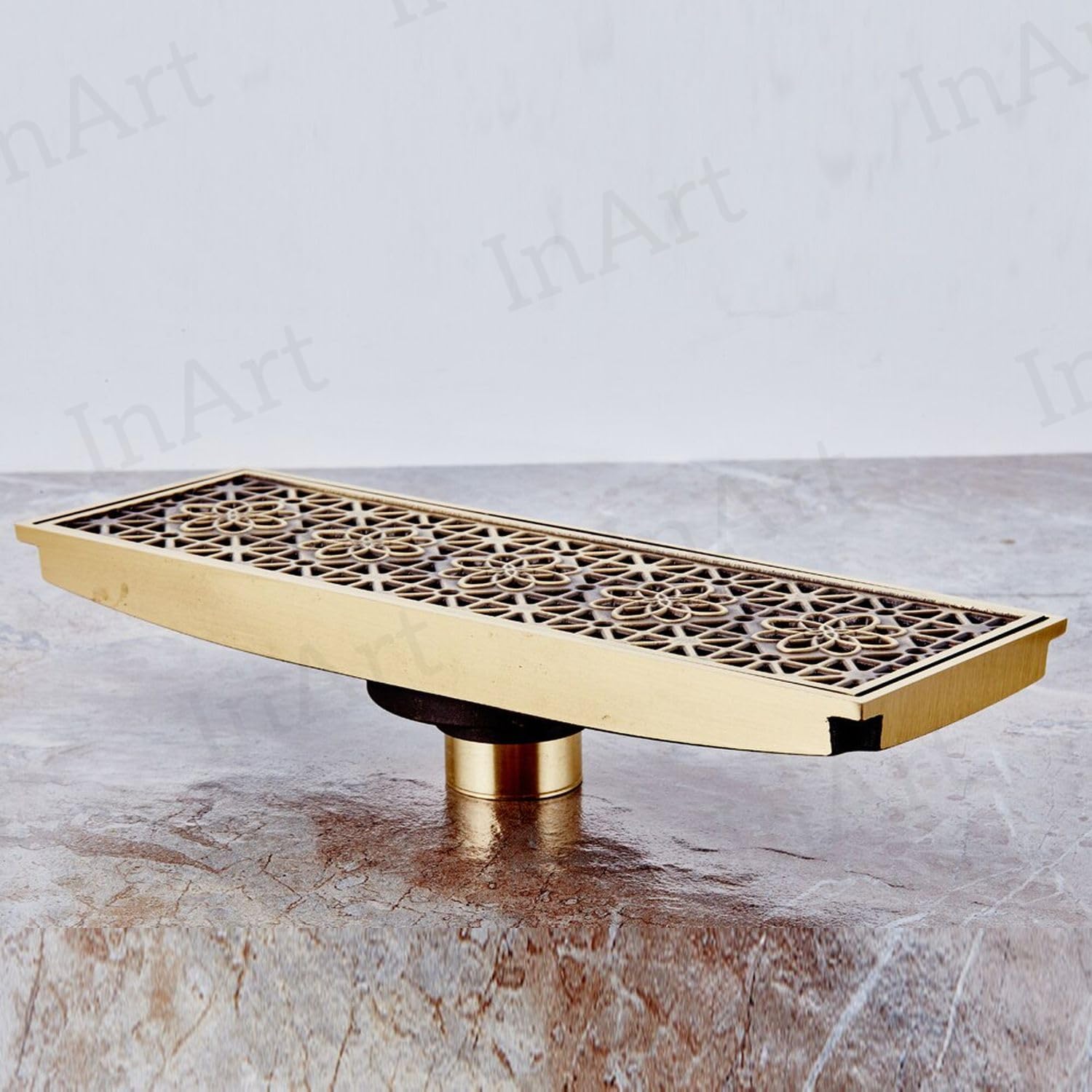 Rectangular brass shower floor drain with center outlet and removable grate in antique brass finish