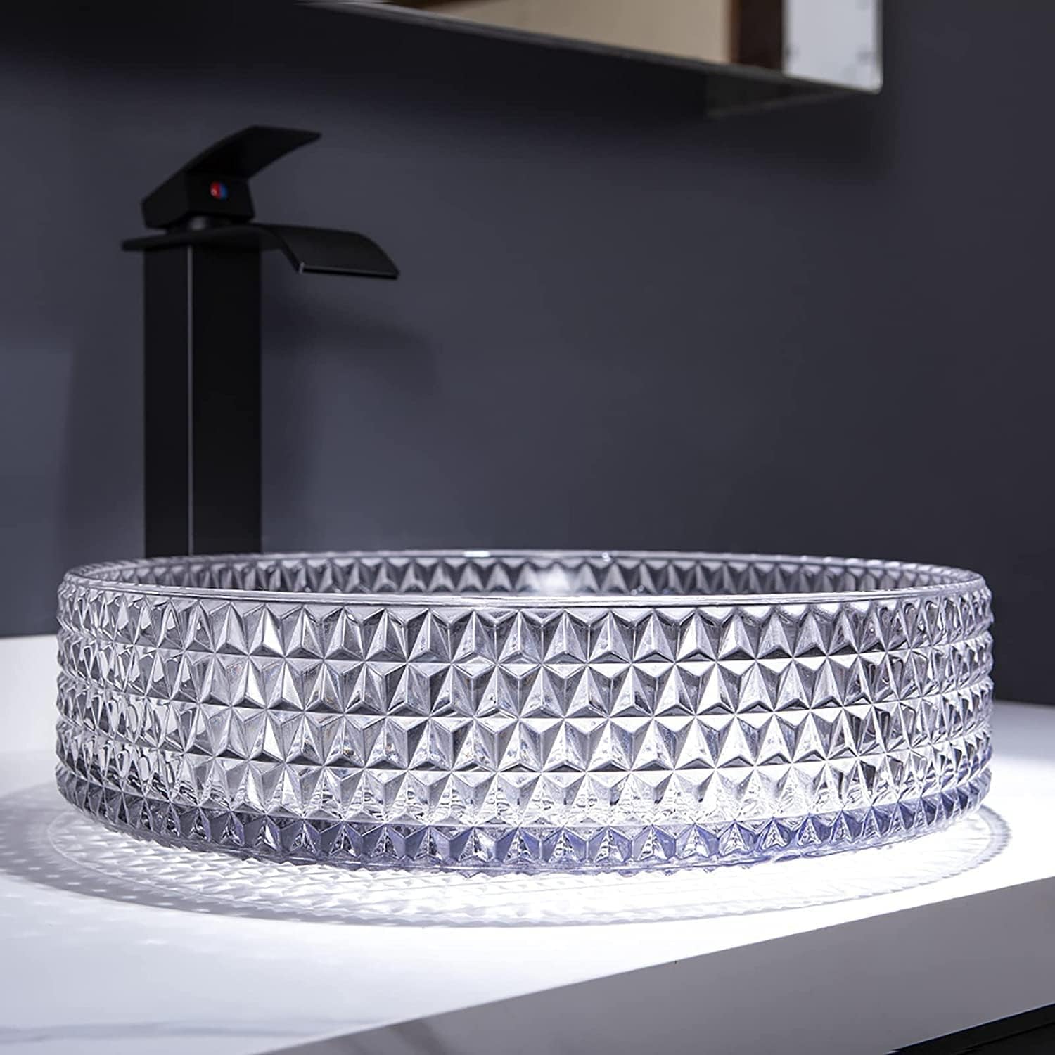 Clear glass round vessel sink with faceted crystal texture, angled countertop installation view