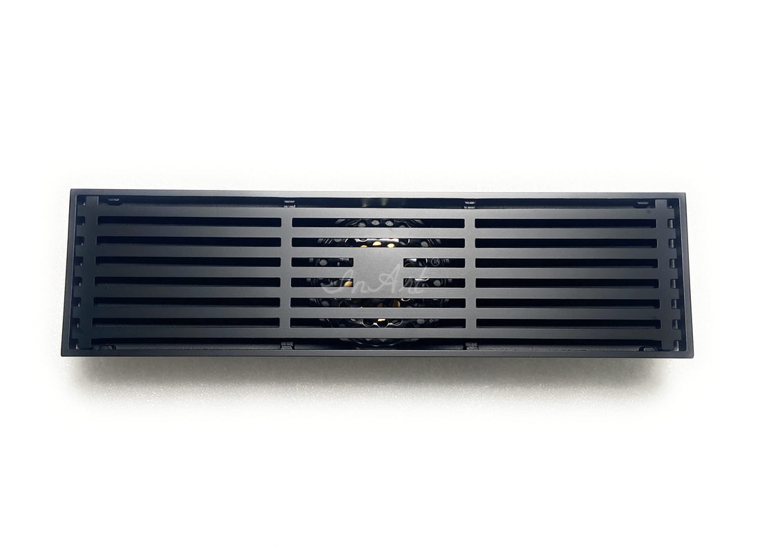 Matte black brass linear shower floor drain with slotted grate cover, rectangular center outlet