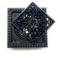 Top view of matte black brass square floor drain cover showing decorative scrollwork grate