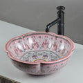 Top view of glossy pink ceramic round vessel sink bowl with multicolor decorative pattern and wavy rim